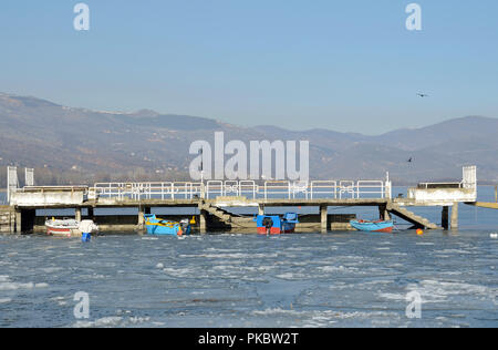 Kleine Dock mit Fischerbooten in Eis See gefangen Stockfoto