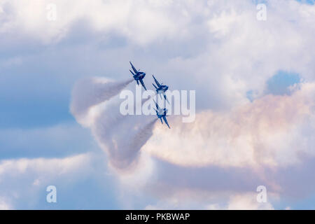 Drei F/A-18 Hornet-Jets der United States Navy Flight Demonstration Squadron fliegen die Blue Angels in enger Formation gegen einen bewölkten Himmel. Stockfoto