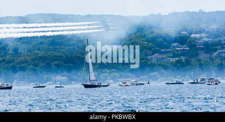 Drei F/A-18 Hornet-Jets der United States Navy Flight Demonstration Squadron, die Blue Angels fliegen tief über Bootsfahrer, die in Traverse City, MI, zusehen. Stockfoto