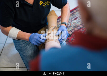 11. September 2018, Nordrhein-Westfalen, Essen: Eine ambulante Krankenschwester hilft, eine alte Frau auf einem Unterstützung Strumpf. Foto: Jana Bauch/dpa Stockfoto