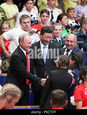 (180912) - WLADIWOSTOK, Sept. 12, 2018 (Xinhua) - der chinesische Präsident Xi Jinping und der russische Präsident Wladimir Putin sprechen mit Kindern auf der Allrussischen Kinder Zentrum "Ocean" während der Teilnahme an gedenken Veranstaltungen anlässlich des 10-jährigen Jubiläums des Center Hosting von Hunderten von chinesischen Kindern aus Regionen durch eine tödliche Erdbeben im Jahr 2008, in Wladiwostok, Russland, Sept. 12, 2018. (Xinhua / Xie Huanchi) (zwx) Stockfoto