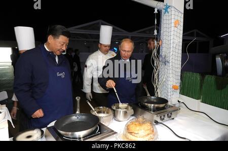 Der russische Präsident Wladimir Putin und der chinesische Präsident Xi Jinping versuchen ihre Hand am Kochen blini in einer Ausstellung während der Eastern Economic Forum im Fernöstlichen Föderalen Universität 11. September, in Wladiwostok, Russland 2018. Stockfoto