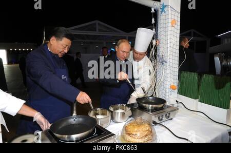 Der russische Präsident Wladimir Putin und der chinesische Präsident Xi Jinping versuchen ihre Hand am Kochen blini in einer Ausstellung während der Eastern Economic Forum im Fernöstlichen Föderalen Universität 11. September, in Wladiwostok, Russland 2018. Stockfoto