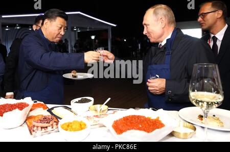 Der russische Präsident Wladimir Putin Toast chinesische Präsident Xi Jinping mit russischem Wodka in einer Ausstellung während der Eastern Economic Forum im Fernöstlichen Föderalen Universität 11. September, in Wladiwostok, Russland 2018. Stockfoto