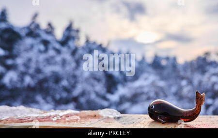 Winter Hintergrund. Glas wal Spielzeug vor park Bäume mit Schnee bedeckt Stockfoto