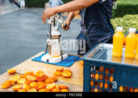 Mann quetscht Orangensaft. Im Freien. Stockfoto