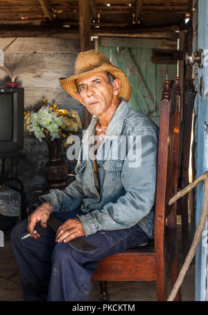 Sancti Spíritus, Kuba. 29. Januar, 2013. Miquel der Haut glitzert von Schweiß, wie er sich hinsetzt, um eine Zigarette zu genießen. Er ist gerade von der Arbeit nach Hause zurück Stockfoto