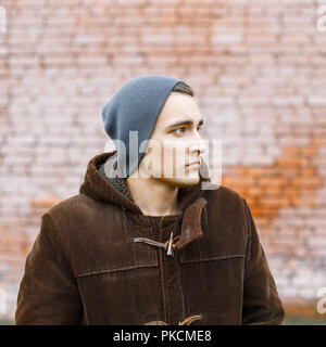 Mann in einem Gap steht vor dem Hintergrund der Red brick wall Stockfoto