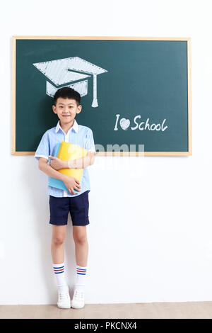 Grundschule Junge stand vor der Tafel Stockfoto