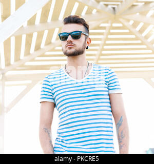 Schöne stilvolle hipster Mann stand am Strand. Stockfoto