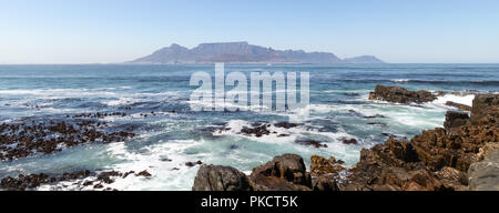 Panorama von Kapstadt, Südafrika. Blick auf Table Mountain. Von Robben Island, wo Nelson Mandela inhaftiert wurde fotografiert. Felsen im Vordergrund. Stockfoto