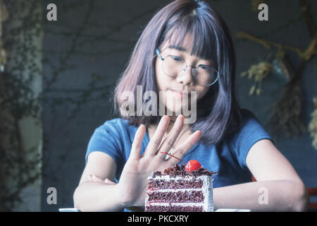 Schöne asiatische Frauen aufhören zu essen in der Zeit Gewichtskontrolle mit Diät essen. Farbton Stockfoto