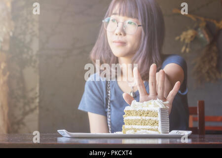 Schöne asiatische Frauen aufhören zu essen in der Zeit Gewichtskontrolle mit Diät essen. Farbton Stockfoto