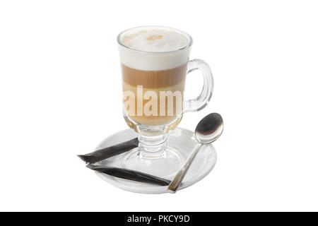 Kaffee mit Milch, Kakao, Schokolade, in einem hohen Glas auf einer Platte mit einem schwarzen Zucker Pakete und einen Teelöffel. Von der Seite. Isoliert weißer backgrou Stockfoto