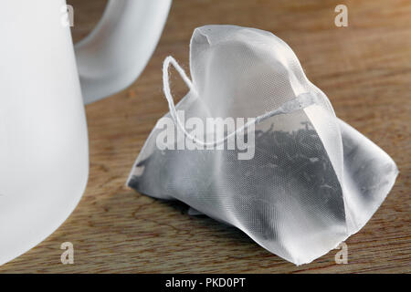 Taschen von Elite Tee in Seide Verpackung und Kaffee Tasse auf einem hölzernen Hintergrund Stockfoto