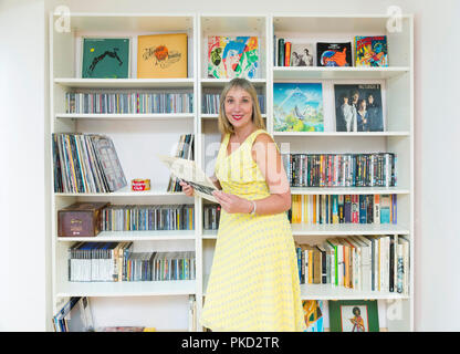 Frau Durchsuchen einer Musik Sammlung von Schallplatten und Compact Discs Stockfoto