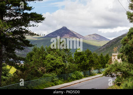 Blick über die Bäume zu Doan Berg in den Mourne Mountains in der Nähe von SIlent Valley, Kilkeel, County Down, Nordirland Stockfoto