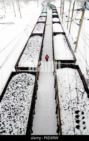 Sibirien, Russland - 20. MÄRZ 2018: Der Arbeitnehmer ist zu Fuß zwischen Güterzüge um Jekaterinburg, Russland. Stockfoto