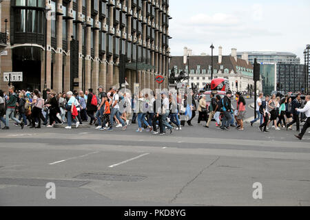 Passanten und Touristen, überqueren Sie die Straße an der Bridge Street Ampel Zebrastreifen außerhalb der Häuser des Parlaments von Westminster London UK Stockfoto