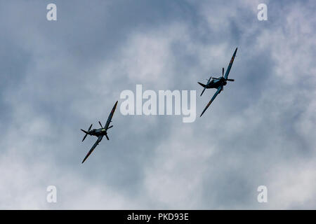 Zwei Spitfires in Formation fliegen, Banken gegen eine trübe August Himmel. Stockfoto