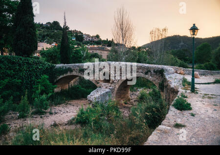 Die römische Brücke über den Torrent de Sant Jordi bei Pollenca auf Mallorca bei Sonnenuntergang. Stockfoto