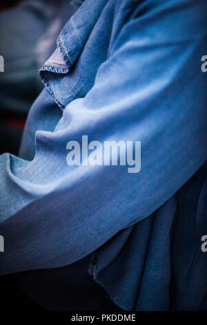 Close Up/Full Frame einer Frau das Tragen eines daed Blue Denim Hemd/Bluse/Top mit einem Fokus auf den Arm und drapierte Ausschnitt Stockfoto