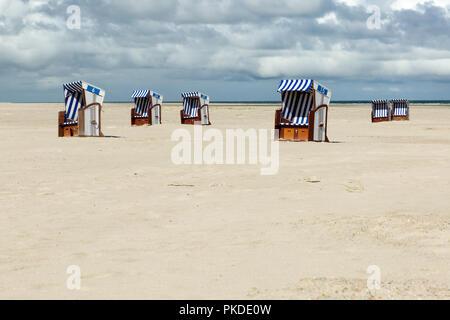 Strandkörben an der Küste der Insel Norderney vor dem Ozean. Großem Betrachtungswinkel Stockfoto