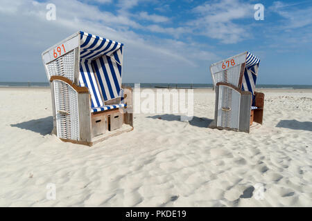 Zwei Strandkörben an der Küste der Insel Norderney vor dem Ozean. Großem Betrachtungswinkel Stockfoto