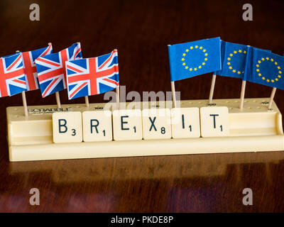 Scrabble Buchstaben Rechtschreibung Brexit in Scrabble Fach mit dem britischen Union Jack und EU-Flaggen auf dunklem Mahagoni Hintergrund Stockfoto