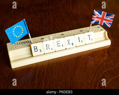 Scrabble Buchstaben Rechtschreibung Brexit in Scrabble Fach mit dem britischen Union Jack und EU-Flagge auf dunklem Mahagoni Hintergrund Stockfoto