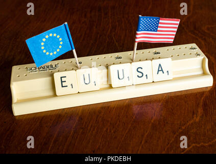 Scrabble Buchstaben Rechtschreibung EU und USA mit Amerikanischen und Europäischen Union Flaggen auf Mahagoni Hintergrund Nation, Handel und Verhandlung Konzept zu veranschaulichen Stockfoto