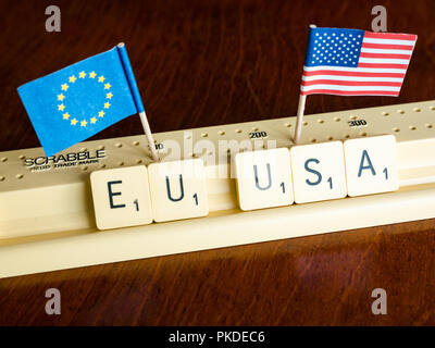 Scrabble Buchstaben Rechtschreibung EU und USA mit Amerikanischen und Europäischen Union Flaggen auf Mahagoni Hintergrund Nation, Handel und Verhandlung Konzept zu veranschaulichen Stockfoto