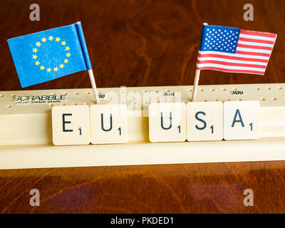 Scrabble Buchstaben Rechtschreibung EU und USA mit Amerikanischen und Europäischen Union Flaggen auf Mahagoni Hintergrund Nation, Handel und Verhandlung Konzept zu veranschaulichen Stockfoto