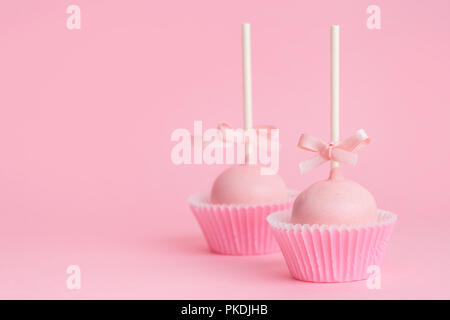 Paar festliche Sahnehäubchen kuchen Pops über rosa Hintergrund, Konzept der Valentinstag Stockfoto