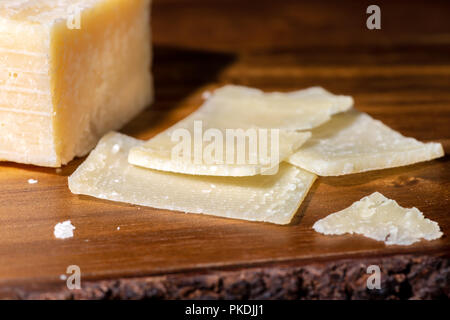 Bis Teil schließen und slaced von frischem Parmesan auf hölzernen Hintergrund Stockfoto