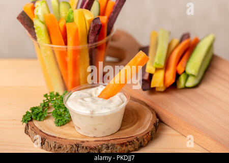 Bunte Karotten und Gurken Julienne gemischt und Sour Cream dip auf Holzbrett, Konzept der gesunden Ernährung Stockfoto