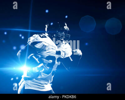 American Football Spieler mit Ball im Feld in der Nacht Stockfoto