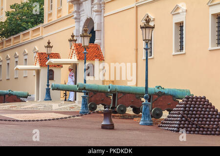 Monaco Ville, Monaco - Oktober 13, 2013: Kanonen und Kanonenkugeln vor dem Prince's Palast auf dem Schlossplatz mit einem Leibwächter an die Post Stockfoto