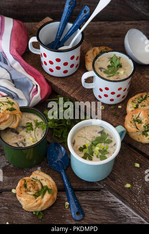 Cremige Pilzsuppe mit frischen Parley im rustikalen Emaille Becher Stockfoto