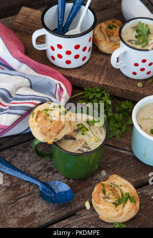 Cremige Pilzsuppe mit frischen Parley im rustikalen Emaille Becher Stockfoto