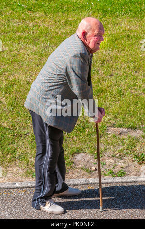 Alter Mann ruht auf gehstock auf bürgersteig - Frankreich. Stockfoto