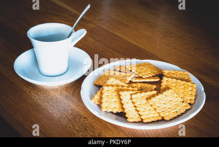 Tasse Kaffee und Kekse auf dem Tisch Stockfoto