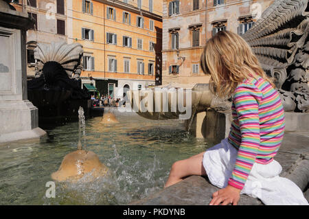 Italien, Latium, Rom, Trastevere, die Piazza di Santa Maria de Trastevere, Kind Abkühlung im Brunnen. Stockfoto