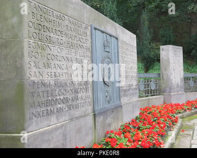 Nahaufnahme einer Stein Monolith & Roter Begonien in der Royal Scots Kriegerdenkmal eingeschrieben mit Schlachten durch die Jahrhunderte; Princes Street Gardens und Edinburgh Stockfoto