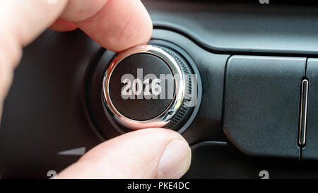 Mann einen Drehknopf oder elektronischer Regler mit dem Datum 2016 auf der Oberseite, als er den Beginn des neuen Jahres in einem konzeptionellen Bild feiert. Stockfoto