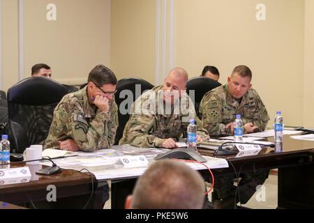 KANDAHAR AIRFIELD, Afghanistan (Juli 25, 2018) - US-Armee General Joseph Votel, Links, Commander für US Central Command, U.S. Army Brig. Gen. Jeffrey Smiley, Mitte, Commander für Zug, Beraten und Unterstützen Command-South und U.S. Army Command Sgt. Maj Anton Hillig, rechts, Senior Soldaten Marktführer für Taac - Süd, die Fähigkeiten von Taac - Süd, 25. Juli 2018 diskutieren, während Votel's Besuch in Kandahar Airfield, Afghanistan. Stockfoto