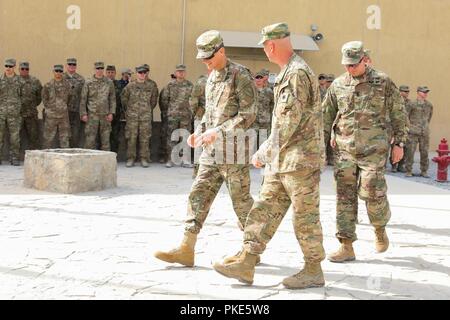 KANDAHAR AIRFIELD, Afghanistan (Juli 25, 2018) - US-Armee General Joseph Votel, Commander für US Central Command, und US-Armee Brig. Gen. Jeffrey Smiley, Commander für Zug, Beraten und Unterstützen Command-South, zu Fuß in die Taac-Compound, Juli 25, 2018, bevor eine Münze Siegerehrung in Kandahar Airfield, Afghanistan. Stockfoto