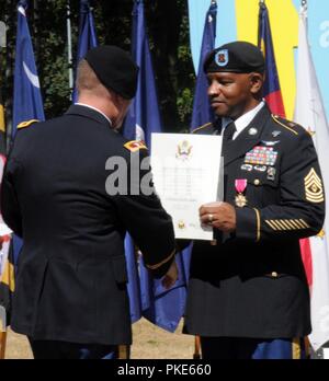 KAISERSLAUTERN, Deutschland - Colonel William S. Galbraith, 21 Theater Sustainment Command stellvertretenden kommandierenden Offizier, stellt eine Bescheinigung über die Pensionierung zu 1 Sgt. Greg A. Thompson, 26. Juli während einer Zeremonie im Panzer Kaserne. Thompson endet seine militärische Karriere nach 27 Jahren Service. Thompson war einer von zwei Unteroffiziere während der Zeremonie in den Ruhestand. 1. Sgt. Gerald L. Brantley zog auch nach 32 Jahren im Dienst. Stockfoto