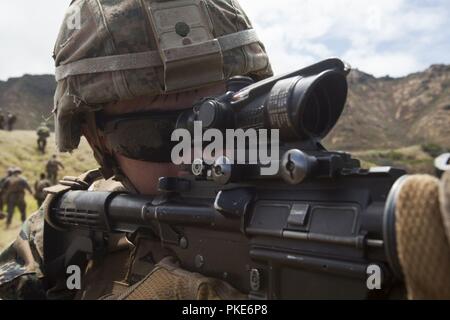 Us Marine Corps Lance Cpl. Wyatt Prettyman, einem truppführer mit Lima Company, 3.BATAILLON, 3. Marine Regiment, III Marine Expeditionary Force, sieht hinten Sicherheit nach einem Brand Team Assault an der Kaneohe Bay Bereich Training Service, Marine Corps Base Hawaii, 26. Juli 2018. Riflemen nutzten ihre individuelle Waffensysteme wie der M203 Granatwerfer, M72 Licht Panzerabwehr: Waffe (Gesetz), M4A1 Assault Rifle und das M27 Sturmgewehr Infanterie ein Brand Team Assault zu führen. Marines mit Indien, Kilo und Limo Unternehmen zusammen gearbeitet, ihre Kommunikation, Führung und tödlich zu verbessern. Stockfoto