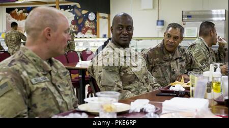 Us-Armee Generalleutnant Michael X. Garrett, US-Army Central kommandierender General, hört zu, wie die US-Armee SPC. Daniel Sullivan, ganz links, mit HHC, 578Th Engineer Brigade Bataillon, Area Support Group-Qatar bei einem Mittagessen Gespräch mit Soldaten im Camp als Saliyah, Katar, 26. Juli 2018. Diese Ausflüge sind eine Gelegenheit für Generalleutnant Garrett mit Soldaten zu engagieren, hören Sie Ihre Eingabe, und geben Sie Feedback. Stockfoto